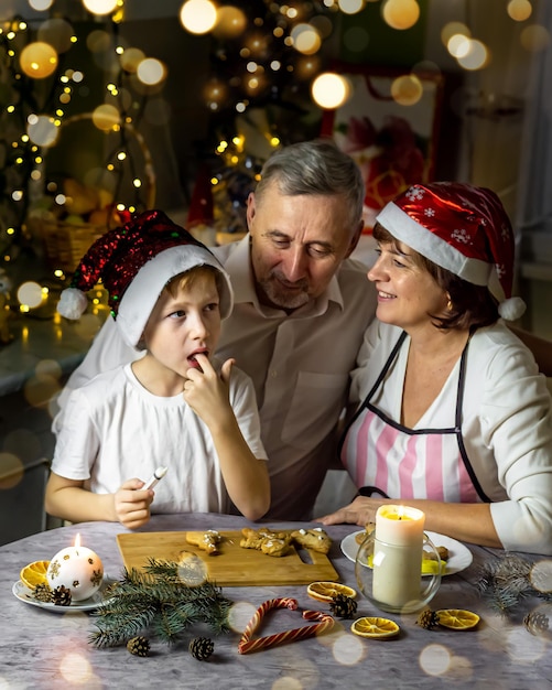 가족 시간 새해 손자 조부모는 집에서 편안하게 크리스마스 진저 쿠키를 준비합니다.