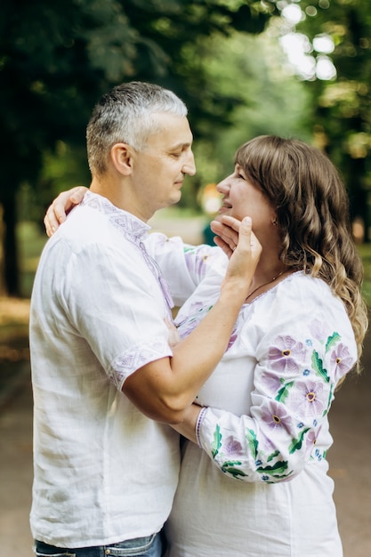 Famiglia insieme nel parco estivo. la donna è incinta