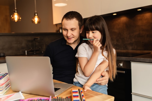 Family togetherness and online learning. Father and daughter do online lesson with laptop at home