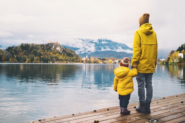 Family Travel Europe Moeder en kind in gele regenjassen kijken naar het meer van Bled in Slovenië