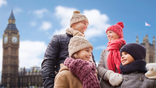 Foto famiglia, viaggi, turismo, vacanze invernali e persone concetto - genitori felici con bambini sullo sfondo di londra