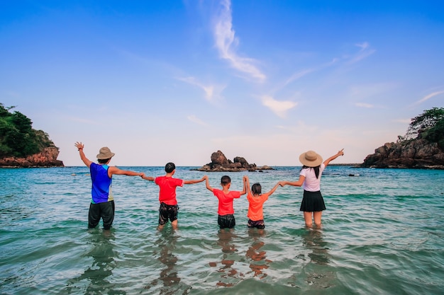 Viaggiatore di famiglia a piedi e godendo sulla spiaggia.