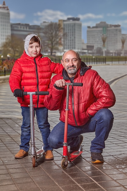 Foto famiglia di due persone, sette e cinquant'anni, cammina lungo le strade della città in abiti pesanti.