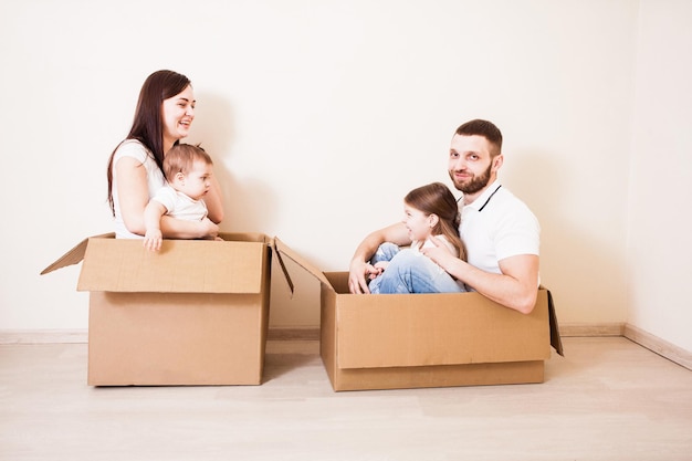 Family unpacking cardboard boxes at new home