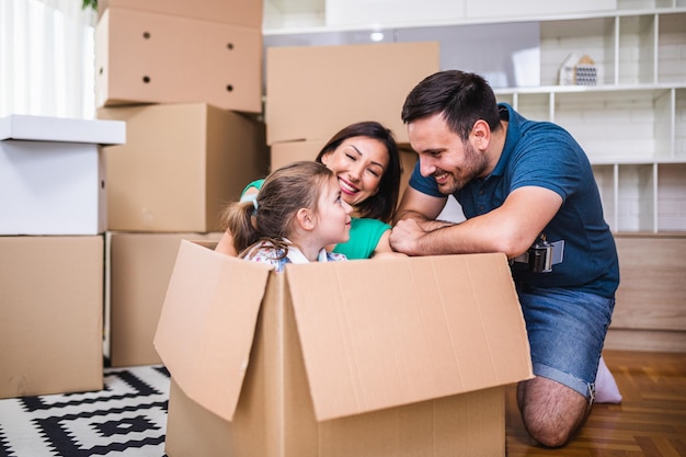 family unpacking cardboard boxes at new home.