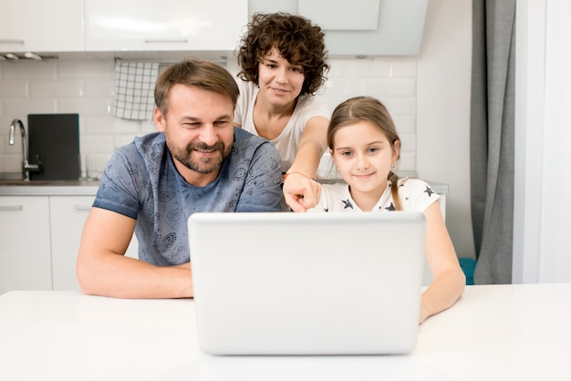 Family Using Laptop in Kitchen