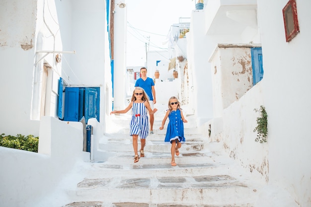 Family vacation in Europe. Father and kids background Mykonos town in Greece