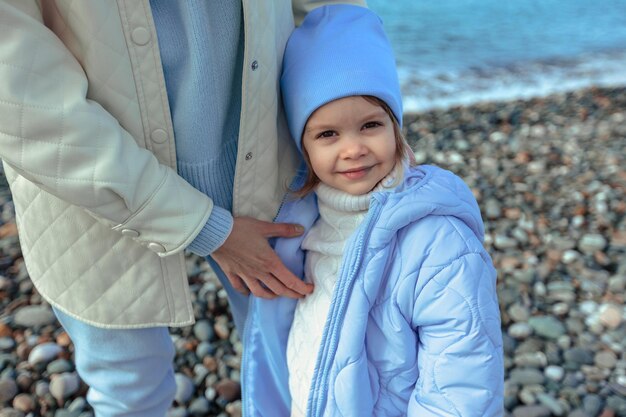 Family vacation at sea in autumn or spring Happy family mother and daughter on a walk along the seashore