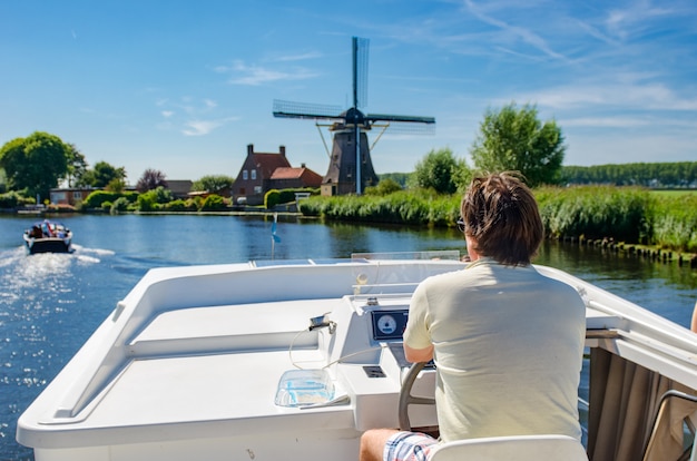 Family vacation, summer holiday travel on barge boat in canal, man by steering wheel on river cruise trip in houseboat in Netherlands