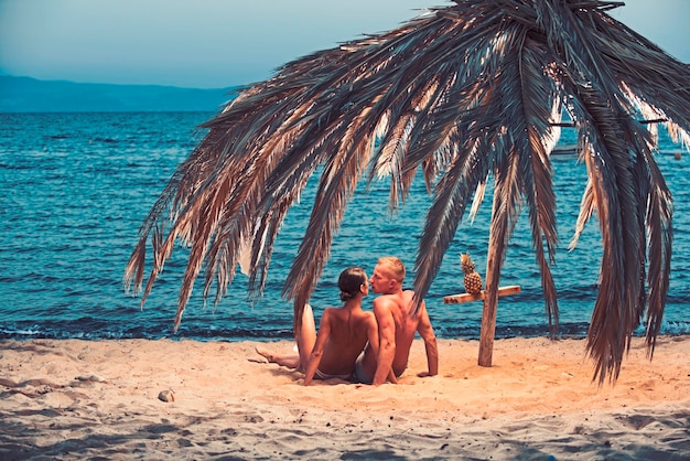 Famiglia e san valentino vacanze estive e vacanze in paradiso relazioni amorose di coppia nuda sulla sabbia donna e uomo sexy con ananas coppia innamorata del corpo sexy rilassarsi sulla spiaggia