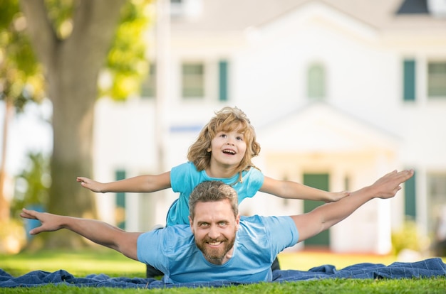 家族の価値観の子供時代と親の親は草の上に小さな男の子と一緒に休む