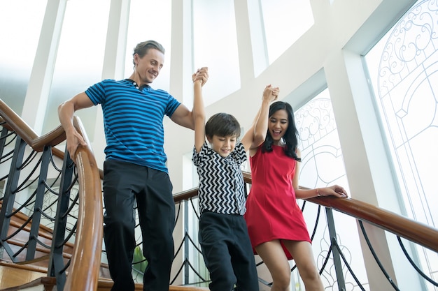 Family walk down the stairs in the house.