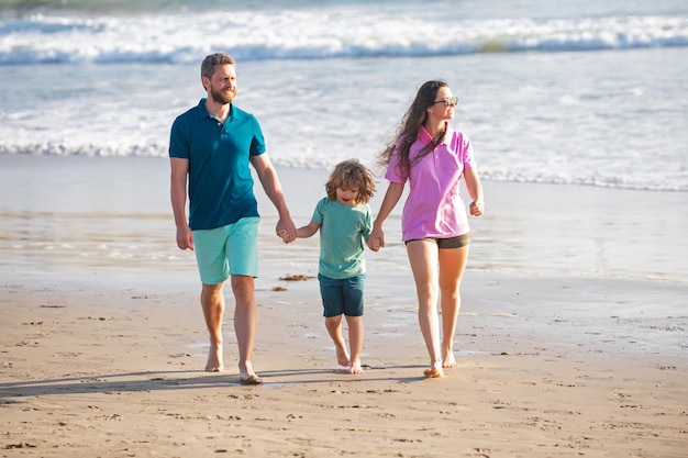 Famiglia che cammina sulla spiaggia madre padre e figlio figlio che trascorrono del tempo insieme vacanze estive in famiglia pa