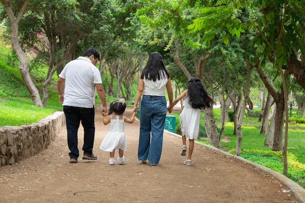 Photo a family walking down a path with their hands in the air