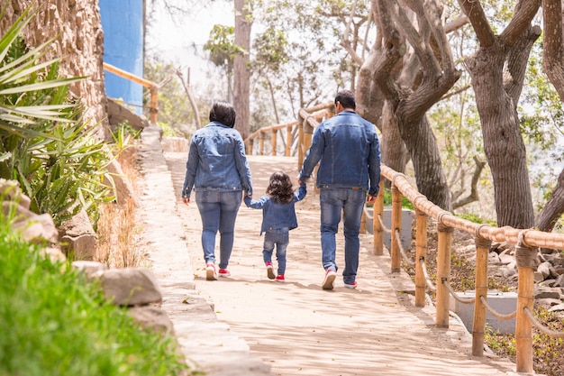 Family walking holding hands on a park in Peru