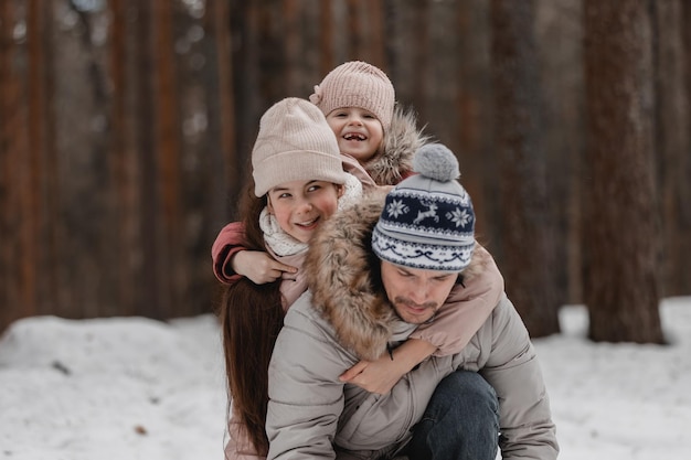 Famiglia che cammina attraverso la foresta d'inverno