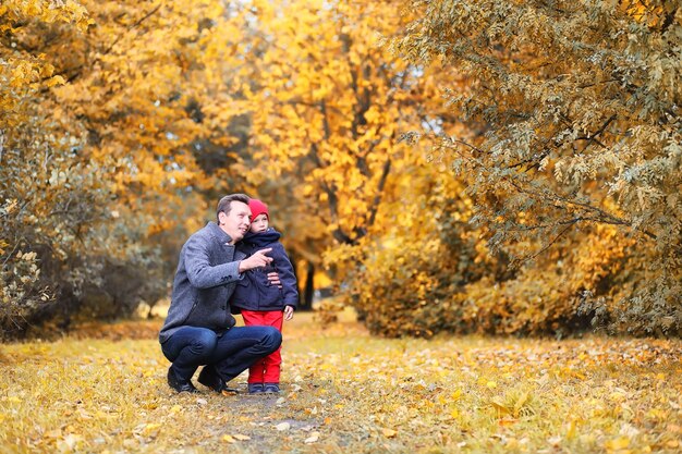 Family walking with children in autumn park in the afternoon