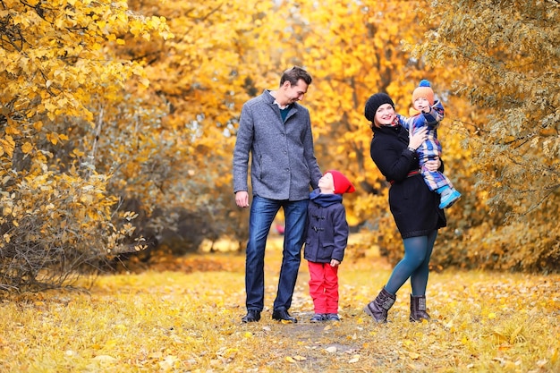 Family walking with children in autumn park in the afternoon