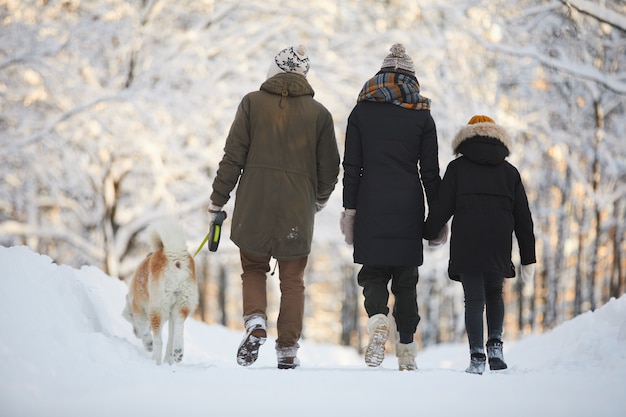 写真 公園で犬と一緒に歩いている家族