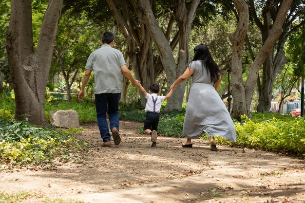 Photo a family walks down a path with their hands in the air