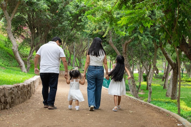 Photo a family walks down a path with their hands in the air