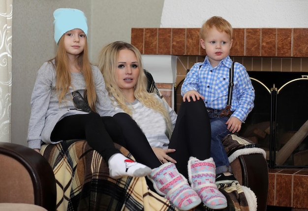 Family warmed by the fireplace sitting on the couch at home