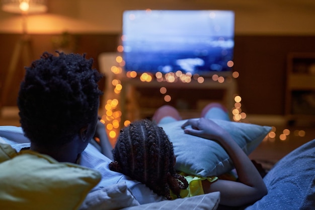 Photo family watching tv together in dark