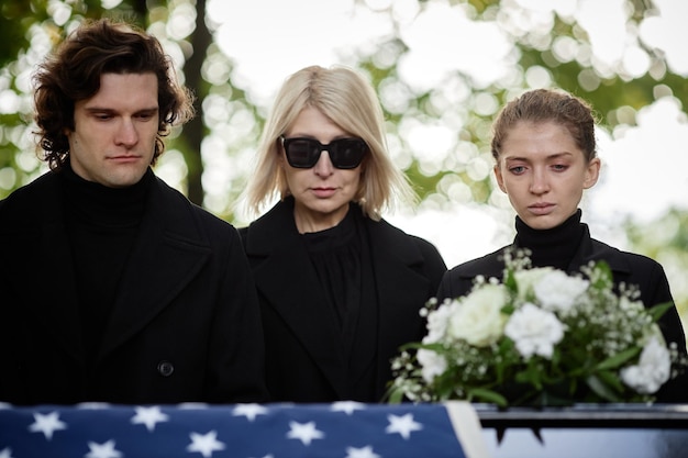 Family wearing black at outdoor funeral ceremony