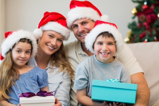 Famiglia che porta il cappello di natale mentre tiene i regali