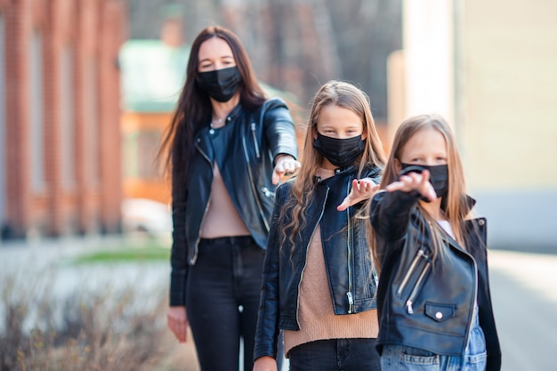 Family wearing a mask on a background of a modern building,