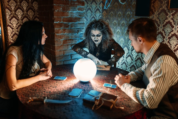 Foto famiglia e strega a tavola con sfera di cristallo