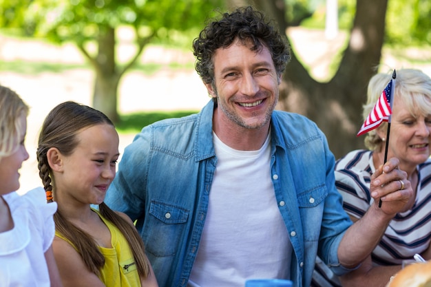 Famiglia con la bandiera americana che ha un picnic