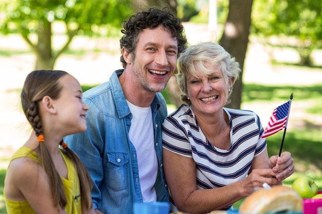 Famiglia con la bandiera americana che ha un picnic