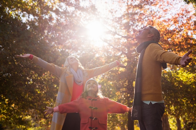 Foto famiglia con le braccia tese contro gli alberi