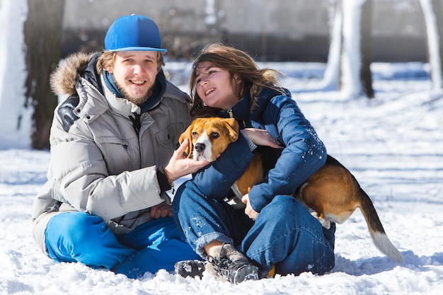 Family with beagle dog during a walk in the winter forest