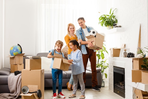 Family with cardboard boxes standing in row at home