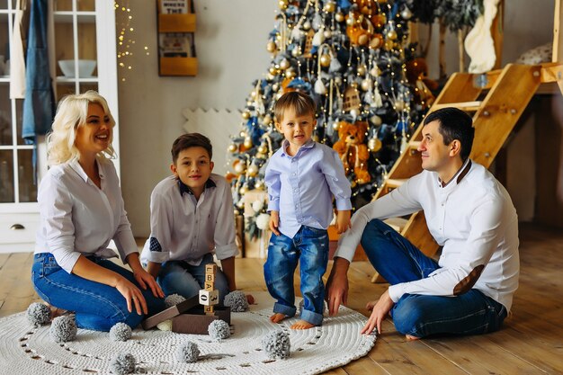 家で一緒にクリスマスを遊んでいる子供たちと家族