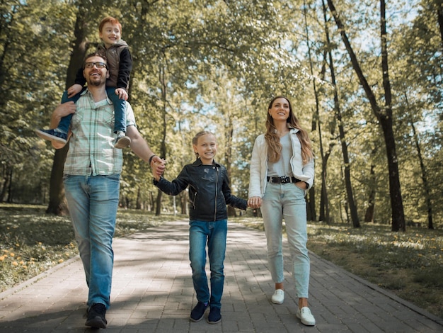 Family with children walking along the path in the city Parkphoto with copy space