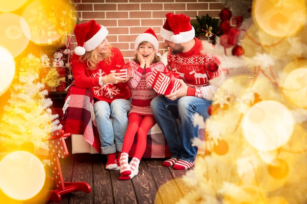 Family with Christmas gift. Mother; father and child having fun together. People playing at home