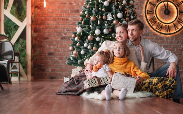 Family with Christmas gifts in a cozy living room