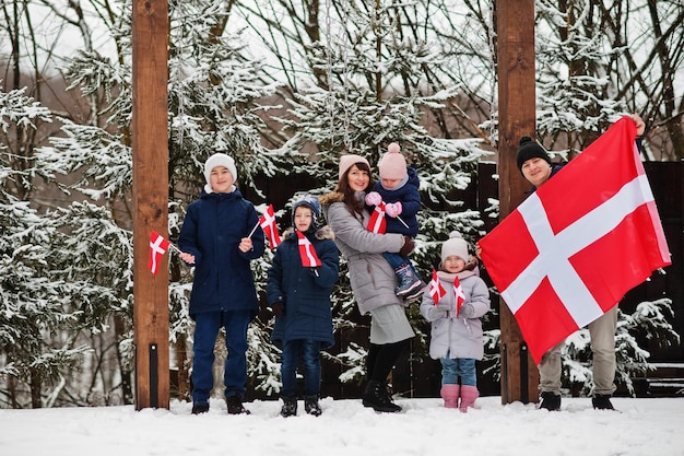 Foto famiglia con bandiere della danimarca all'aperto in inverno viaggio nei paesi scandinavi popoli danesi più felici