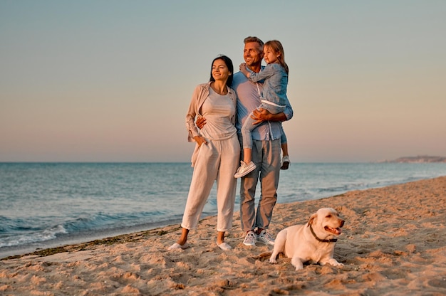 Семья с собакой на пляже