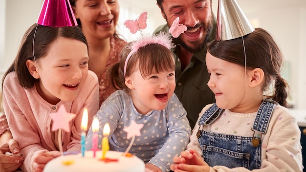 一緒に家でパーティーで誕生日を祝うダウン症の娘を持つ家族