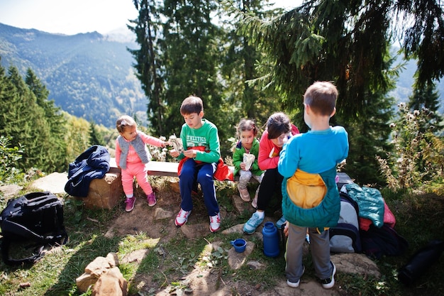 사진 산에서 쉬고 있는 4명의 아이가 있는 가족 아이들과 여행 및 하이킹