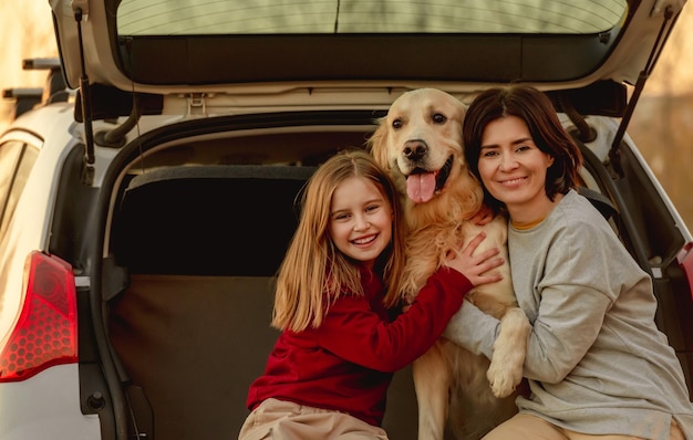 Family with golden retriever dog in car