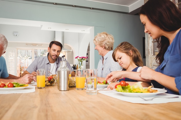 Family with grandparents sitting at dining table