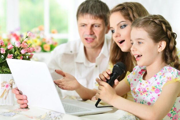 Family with laptop singing karaoke