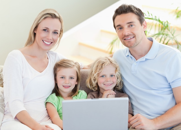 Family with laptop on the sofa