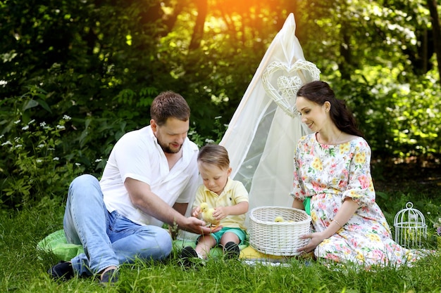 Family with little yellow duckling in summer Park