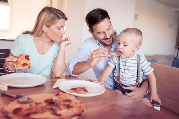 Family with pizza in kitchen